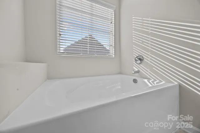 a bathroom with a bathtub next to a window