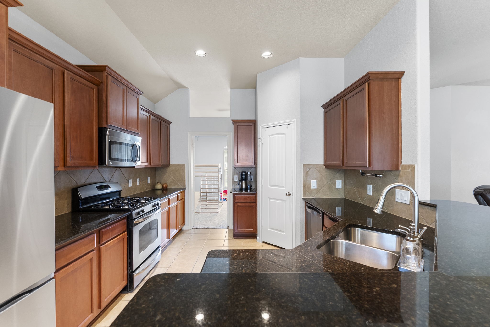 174 Maple Grove Drive Conroe, TX 77384 - Photo 8 of 26 Granite countertops and stainless steel appliances, including a gas range, make this kitchen as functional as it is beautiful.