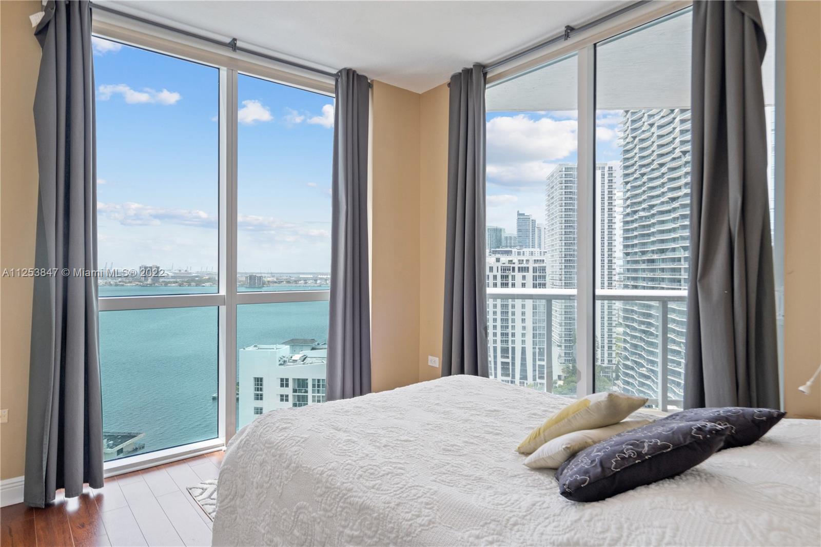 480 Northeast 30th Street, Unit 2003 Miami, FL 33137 - Photo 11 of 17 a bedroom with a large window and a balcony