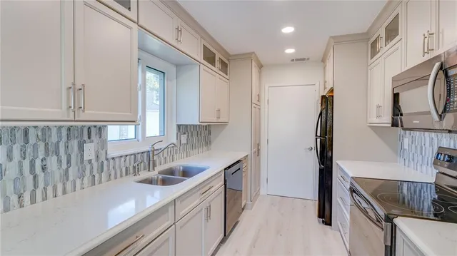 a kitchen with stainless steel appliances a stove a sink and a microwave