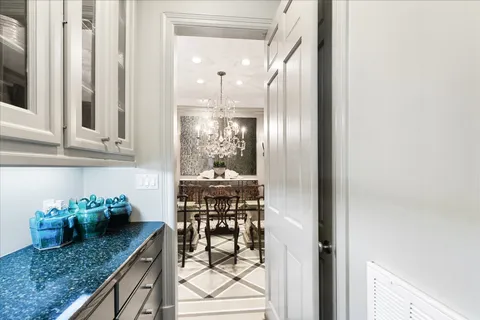 a kitchen with stainless steel appliances granite countertop a stove top oven a sink a refrigerator with white cabinets and wooden floor