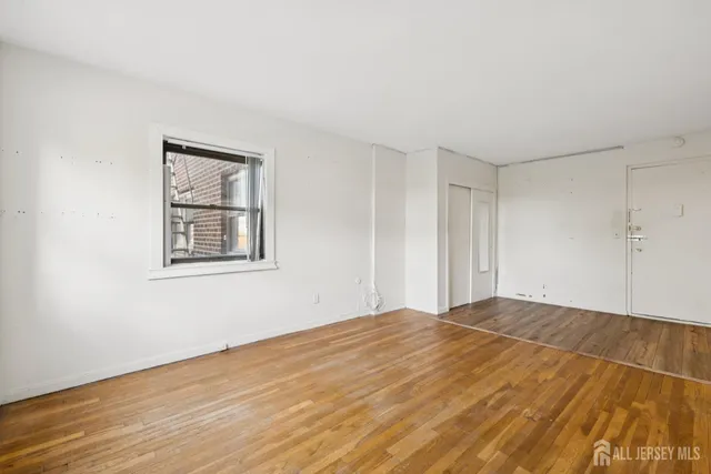 a view of empty room with wooden floor