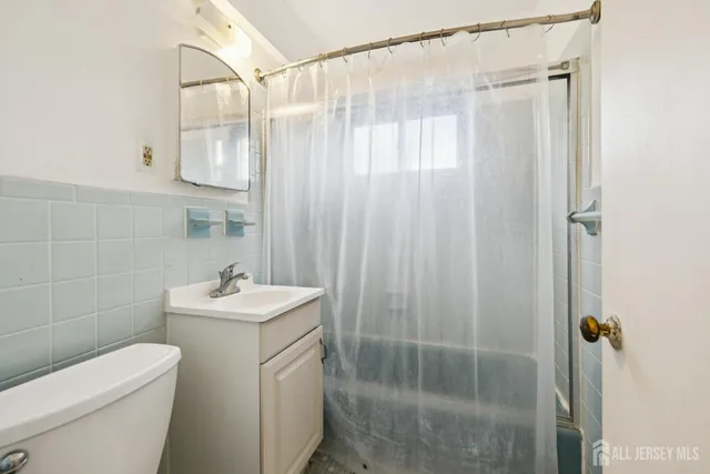 a bathroom with a shower a toilet and sink