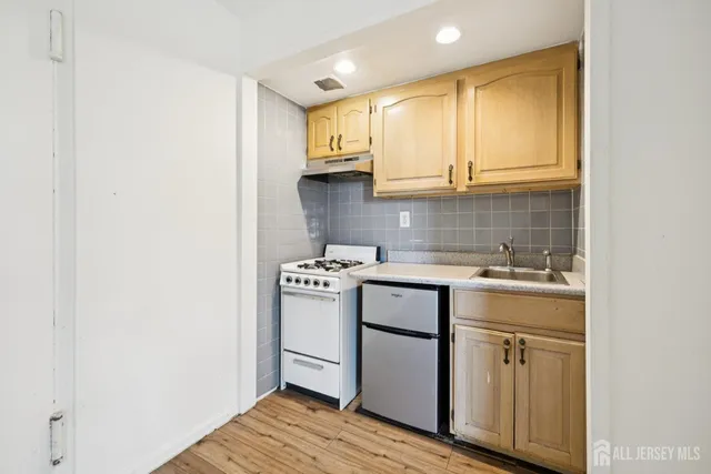 a kitchen with a sink cabinets and wooden floor