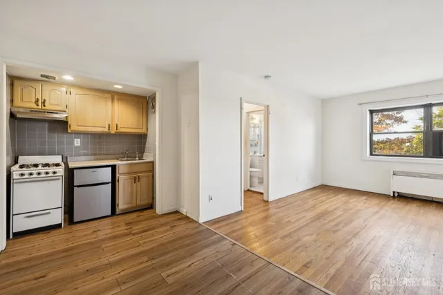 a kitchen with granite countertop a stove a sink and a refrigerator