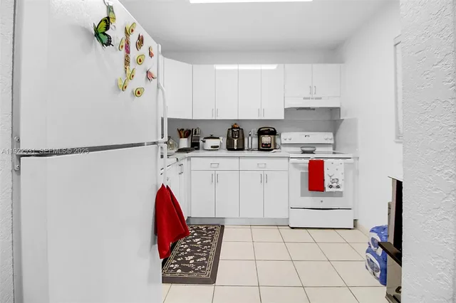 a kitchen with stainless steel appliances granite countertop a refrigerator sink stove and white cabinets
