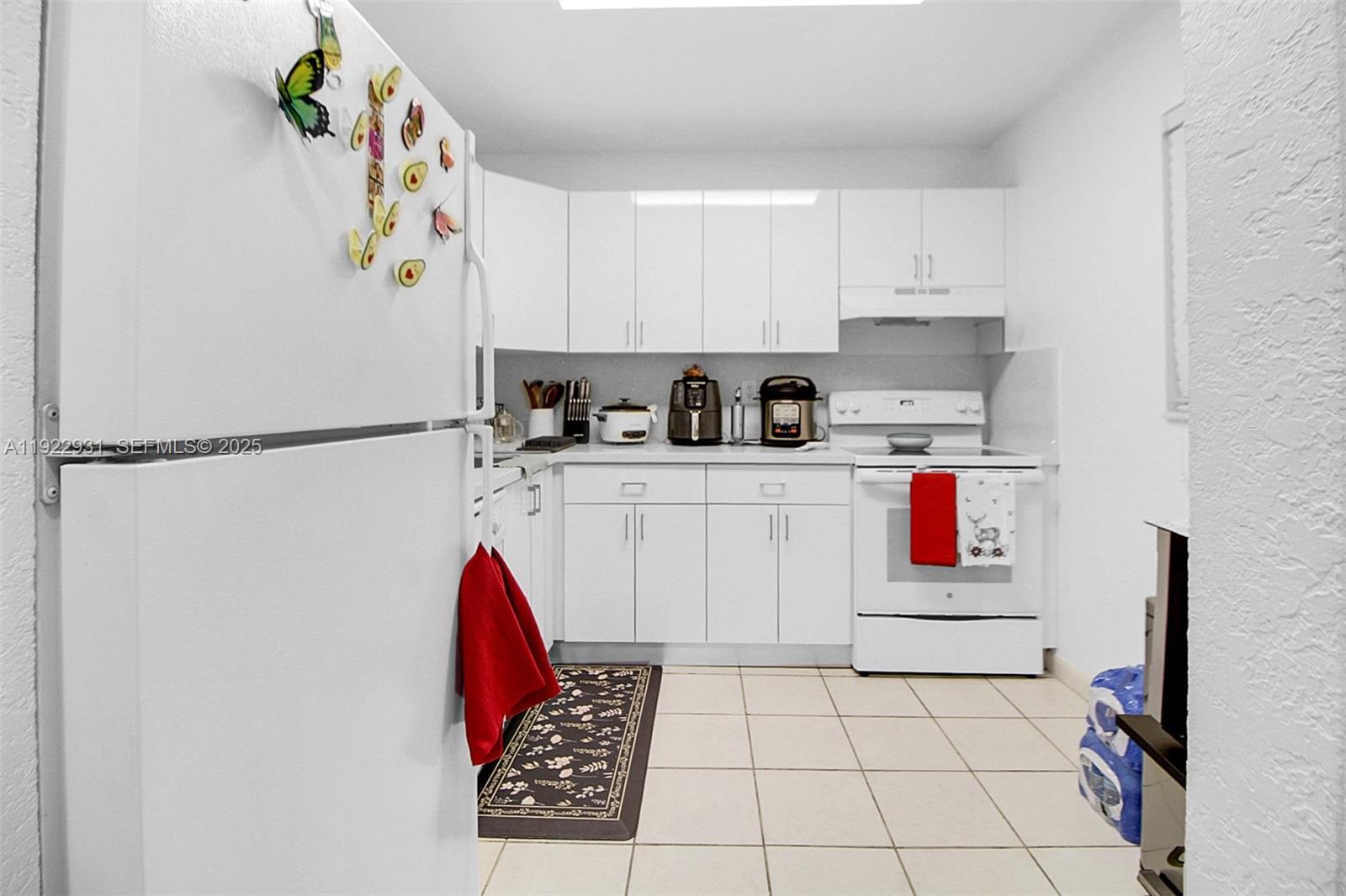7700 Camino Real, Unit D101 Miami, FL 33143 - Photo 2 of 13 a kitchen with stainless steel appliances granite countertop a refrigerator sink stove and white cabinets