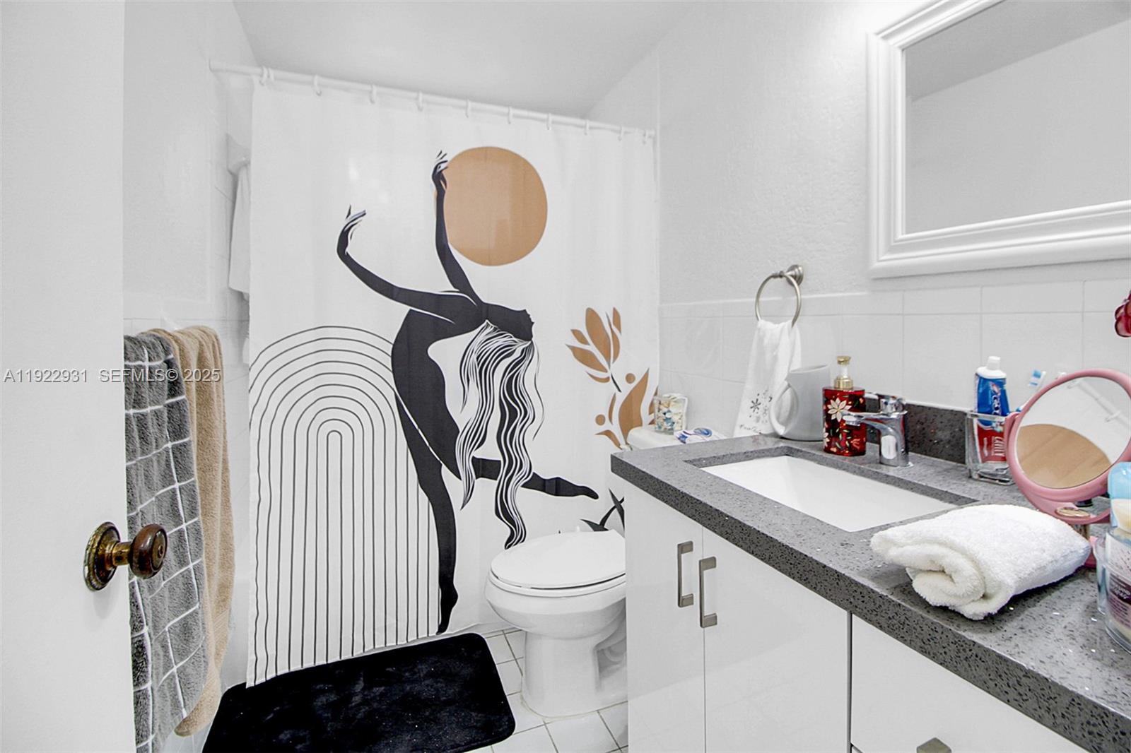 7700 Camino Real, Unit D101 Miami, FL 33143 - Photo 5 of 13 a bathroom with a granite countertop sink and a mirror