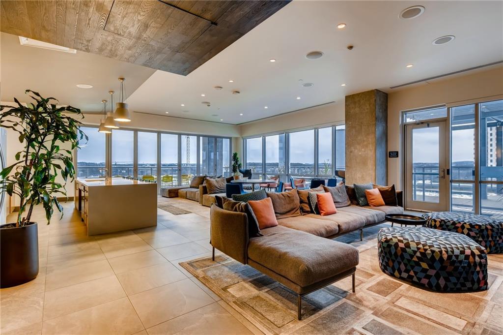 222 West Avenue, Unit 2207 Austin, TX 78701 - Photo 29 of 30 Spacious common area featuring extensive floor-to-ceiling windows, recessed lighting, tile flooring, and a large central island with pendant lighting