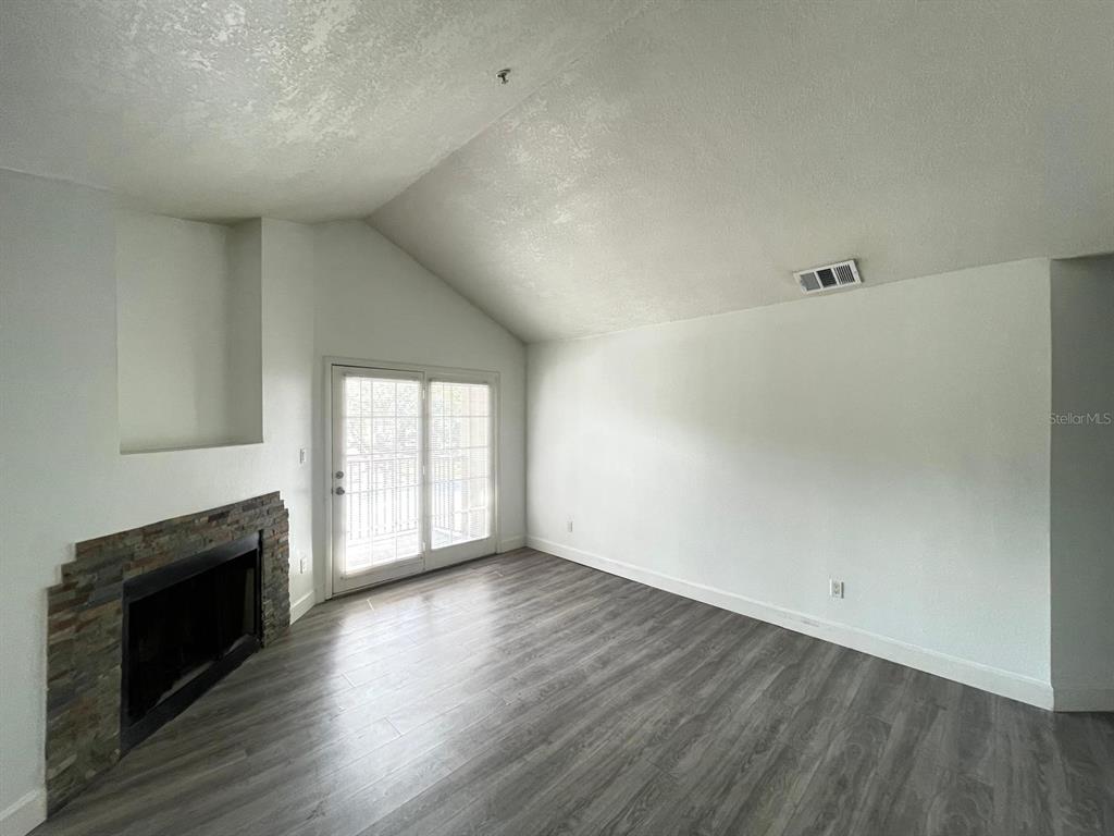 236 Afton Square, Unit 305 Altamonte Springs, FL 32714 - Photo 18 of 30 a view of empty room with wooden floor and fireplace