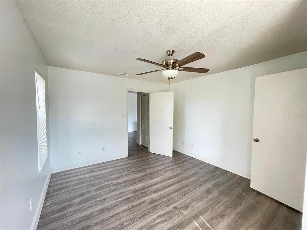 236 Afton Square, Unit 305 Altamonte Springs, FL 32714 - Photo 26 of 30 an empty room with wooden floor and a ceiling fan