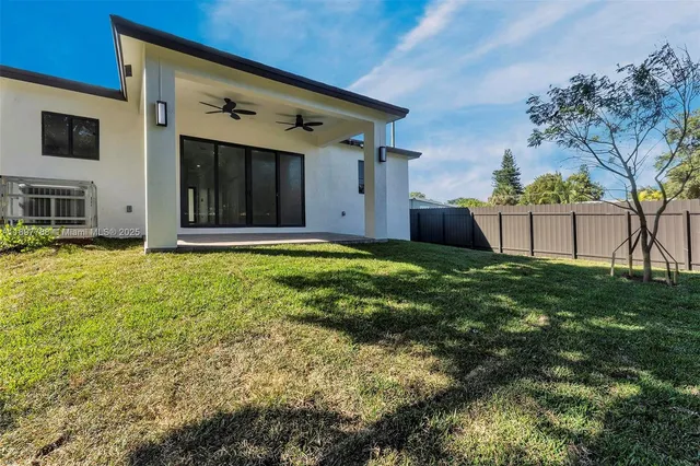 a view of a house with a big yard and large tree