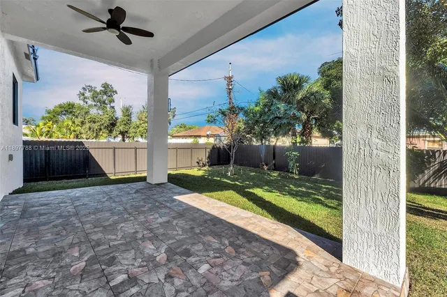 a view of backyard with wooden fence