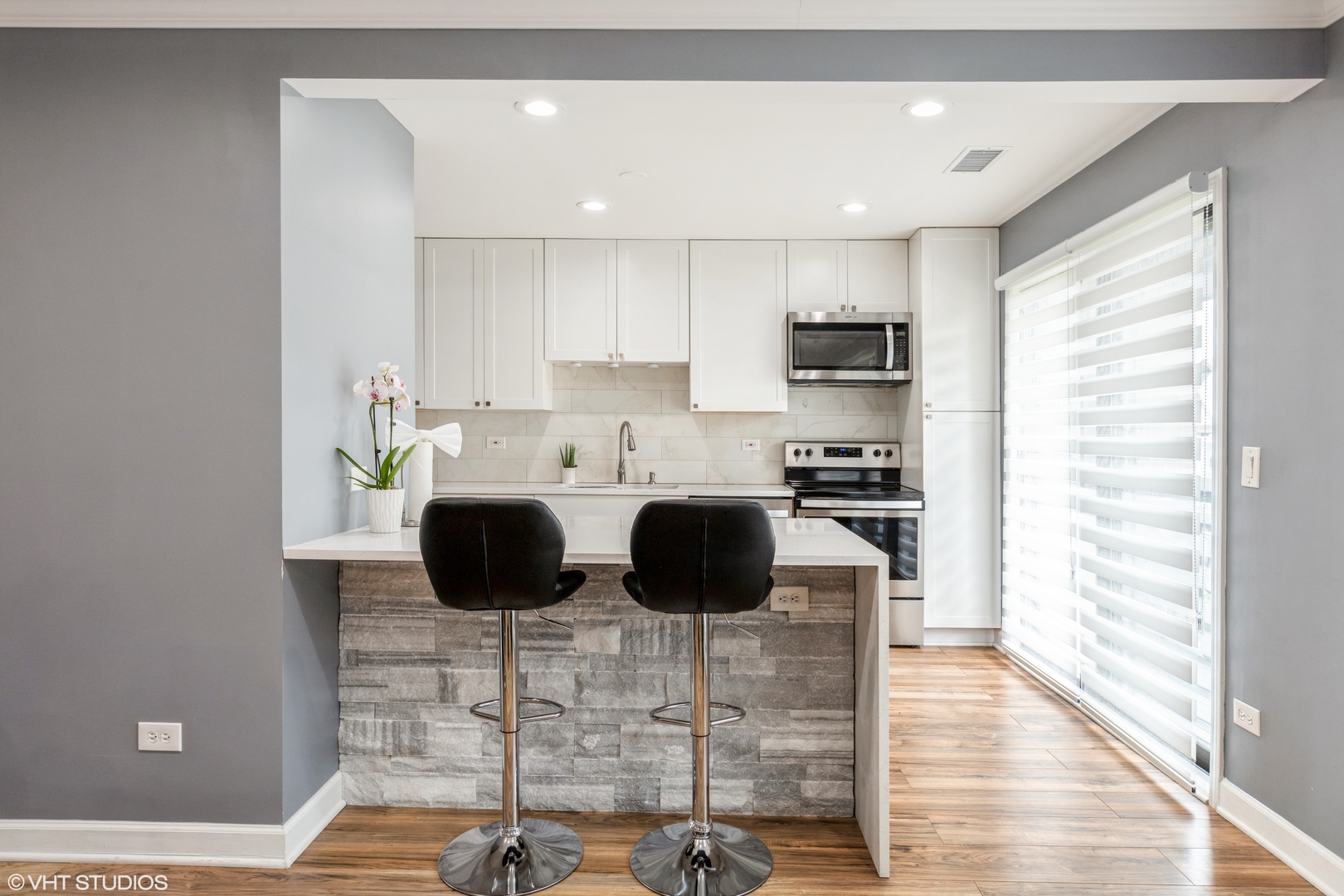 232 Stanhope Drive, Unit C Willowbrook, IL 60527 - Photo 5 of 12 a kitchen with stainless steel appliances kitchen island granite countertop a refrigerator and a stove top oven