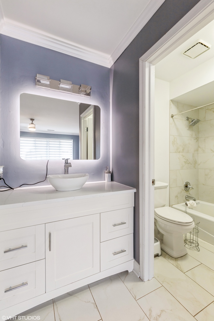 232 Stanhope Drive, Unit C Willowbrook, IL 60527 - Photo 8 of 12 a bathroom with a toilet sink and mirror