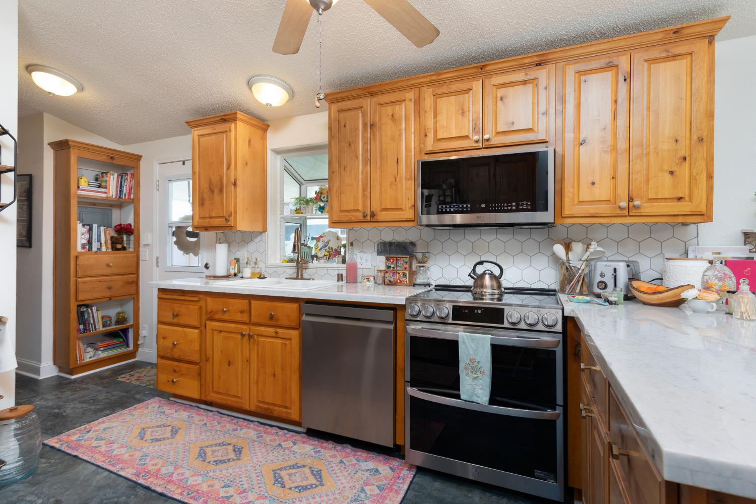 8701 Highway 41, Unit 52 Fresno, CA 93720 - Photo 61 of 66 a kitchen with stainless steel appliances granite countertop a stove sink microwave and cabinets