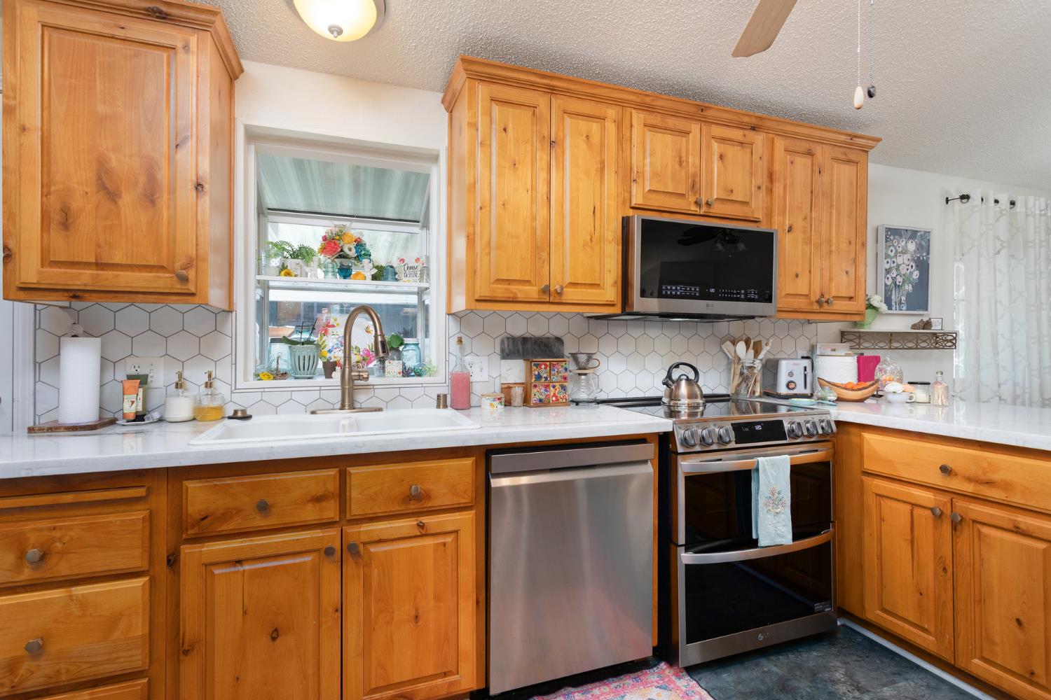 8701 Highway 41, Unit 52 Fresno, CA 93720 - Photo 62 of 66 a kitchen with stainless steel appliances granite countertop a sink a stove and cabinets