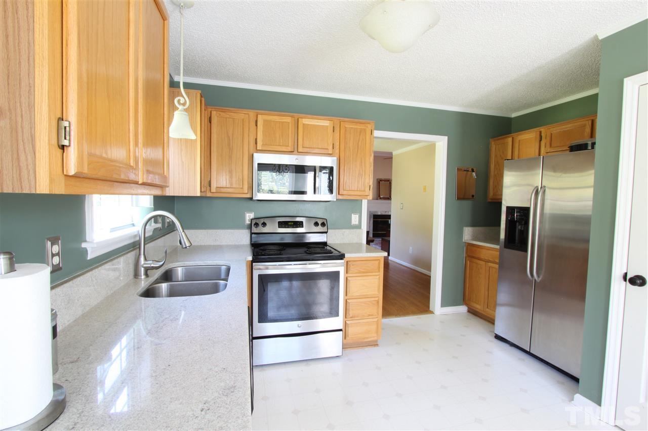 9416 Dawnshire Road Raleigh, NC 27615 - Photo 3 of 17 a kitchen with stainless steel appliances granite countertop a refrigerator a stove a sink and a window