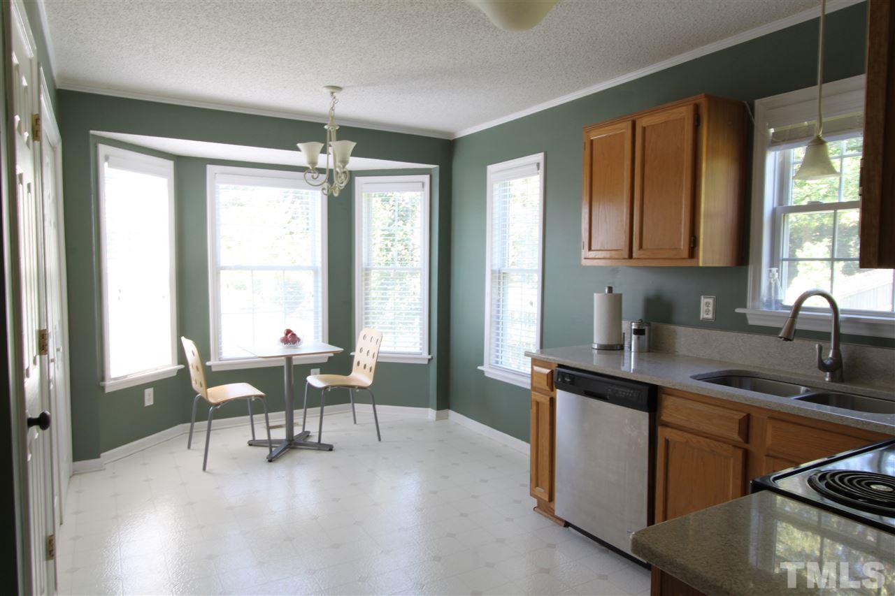 9416 Dawnshire Road Raleigh, NC 27615 - Photo 4 of 17 a kitchen with granite countertop a sink dining table and chairs