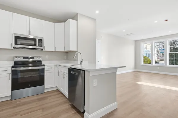 a kitchen with stainless steel appliances granite countertop a stove a sink and a microwave
