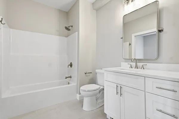 a bathroom with a granite countertop sink a toilet and a bathtub