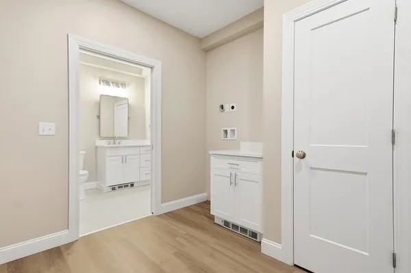 a view of a room with wooden floor and a bathroom