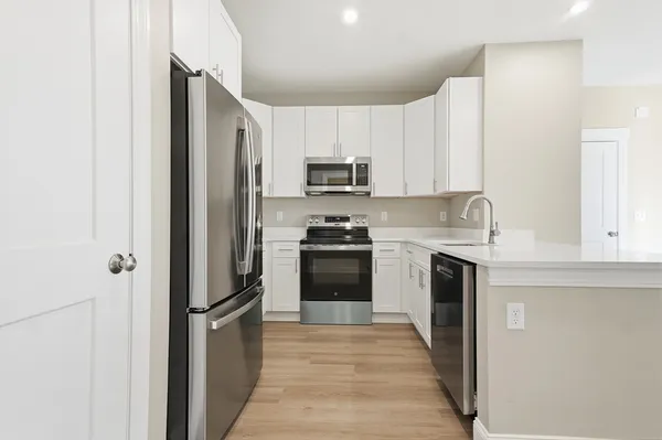 a kitchen with granite countertop white cabinets and stainless steel appliances