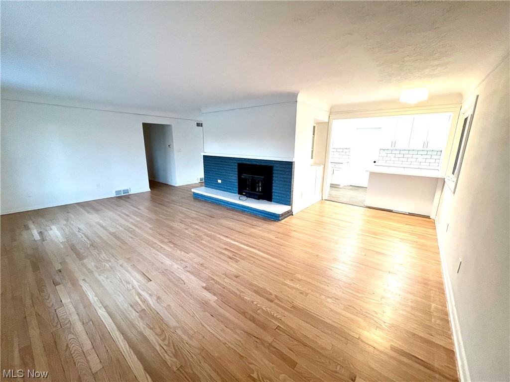 7687 Ragall Parkway Cleveland, OH 44130 - Photo 5 of 37 Unfurnished living room with light wood-type flooring and a fireplace