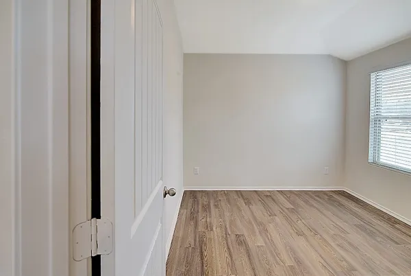 a view of a room with wooden floor and a window