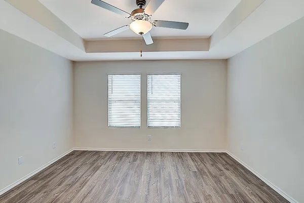 an empty room with a window and wooden floor
