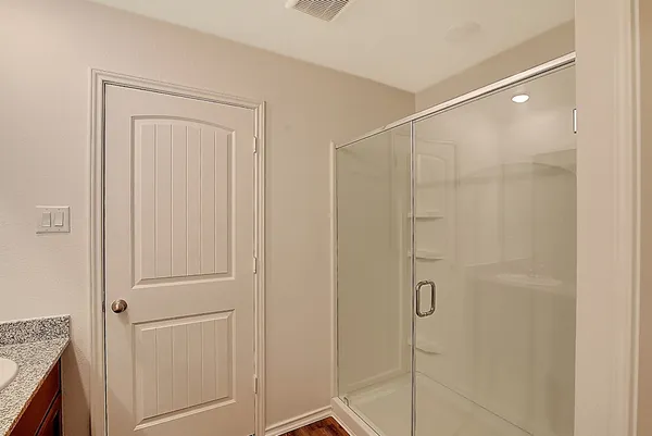 a bathroom with a shower and a glass door