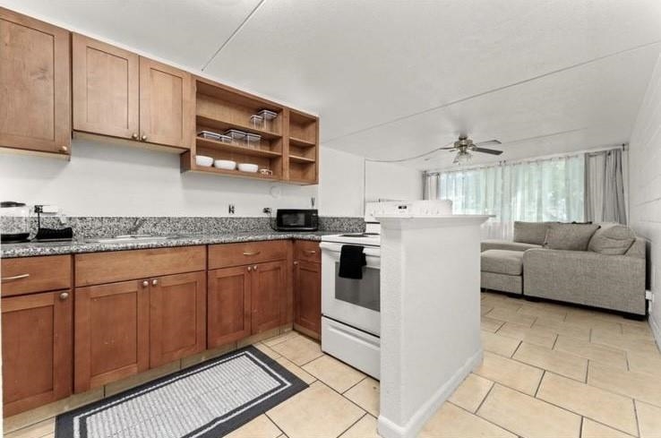 111 Kahului Beach Road, Unit B112 Kahului, HI 96732 - Photo 4 of 15 a kitchen with stainless steel appliances granite countertop a stove a sink and a refrigerator