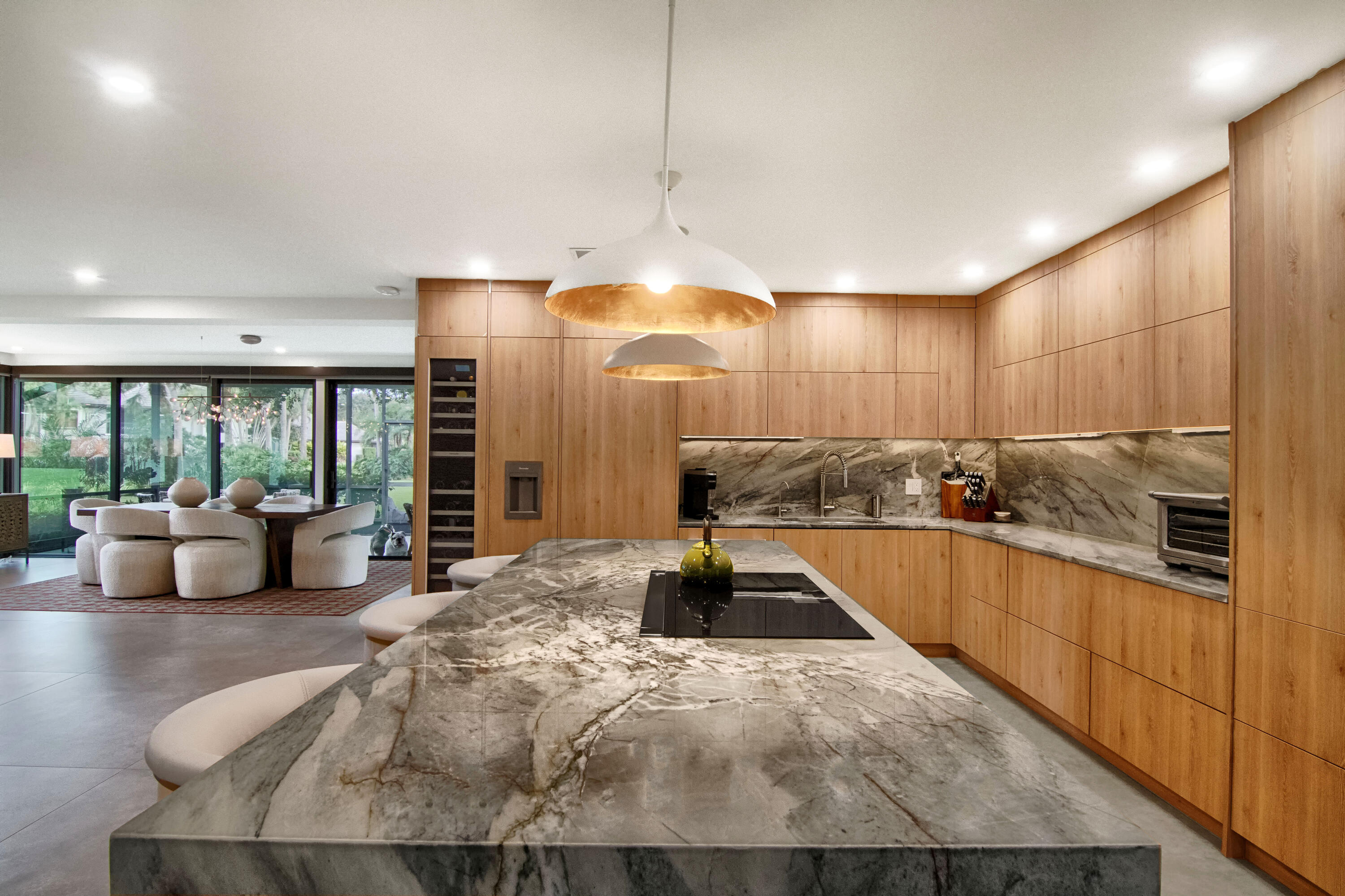 13244 Polo Club Road, Unit C105 Wellington, FL 33414 - Photo 9 of 42 a large kitchen with kitchen island a large counter top a chandelier and living room view