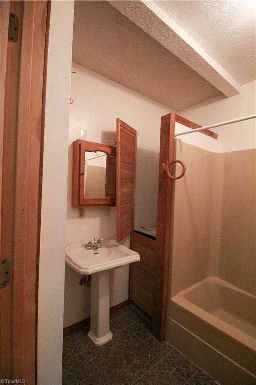 2067 Riverside Circle Eden, NC 27288 - Photo 43 of 50 Full bathroom inside the primary bedroom. Shower/tub combo, pedestal sink, vinyl flooring