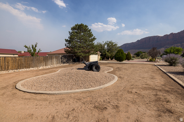 4297 Beeman Road Moab, UT 84532 - Photo 37 of 59 Expansive front yard featuring a defined gravel bed and a large shade tree