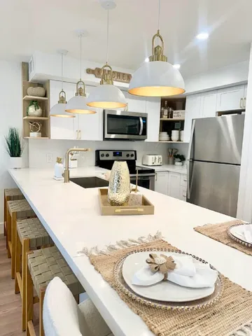 a kitchen with kitchen island a stove a sink and a refrigerator