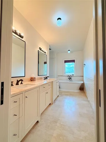a bathroom with a tub sink shower and mirror