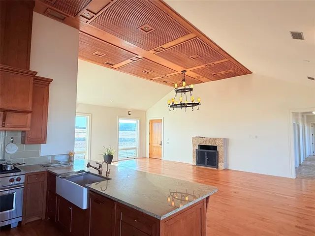 a kitchen with stainless steel appliances wooden floor and large windows