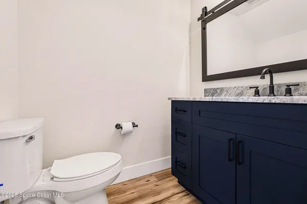 a bathroom with a granite countertop toilet sink and mirror