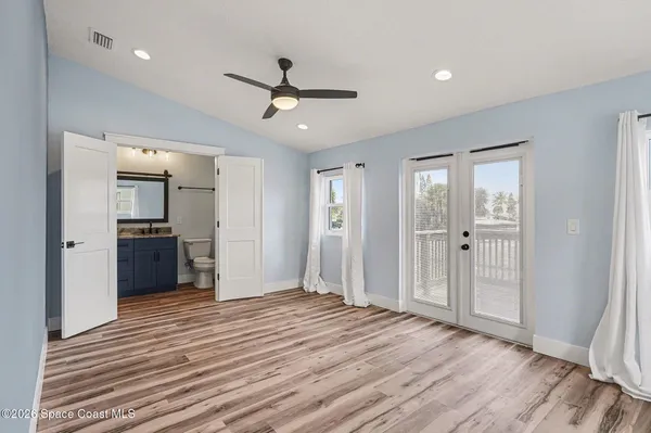 a view of a big room with wooden floor and a kitchen