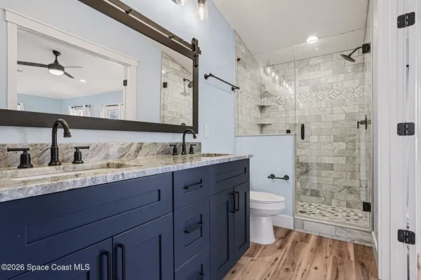 a bathroom with a sink a toilet and shower
