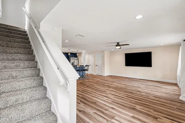 a view of a livingroom with wooden floor and stairs