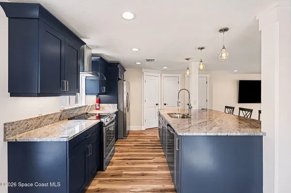 a large kitchen with kitchen island a sink appliances and a counter top space