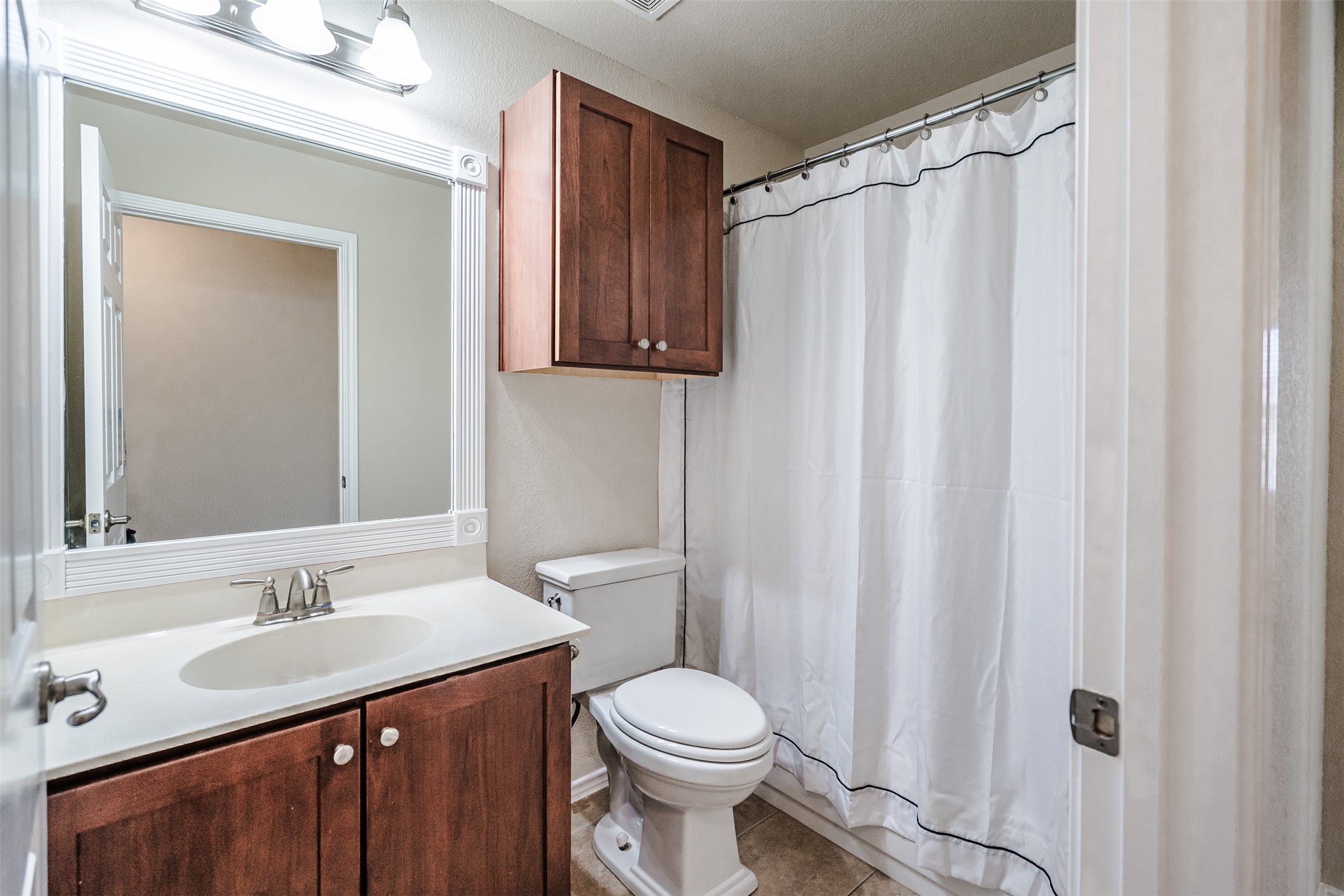 2404 Christoff Loop Austin, TX 78748 - Photo 9 of 24 a bathroom with a sink a toilet and shower curtain