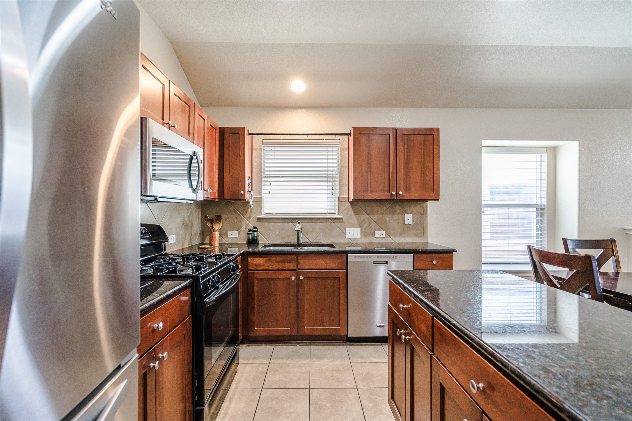 2404 Christoff Loop Austin, TX 78748 - Photo 6 of 24 a kitchen with stainless steel appliances granite countertop sink stove top oven and cabinets