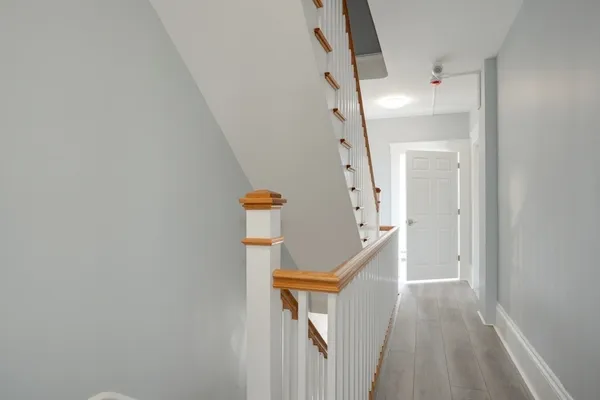 a view of staircase with railing and white walls