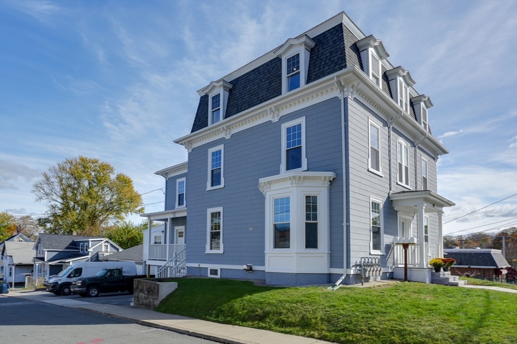 47 Mechanic Street, Unit 2 Marlborough, MA 01752 - Photo 4 of 26 a front view of a building with a yard and car parked