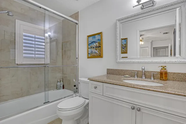 a bathroom with a granite countertop sink a toilet and a bathtub