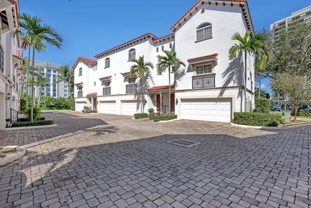 a view of a house with a yard and palm trees