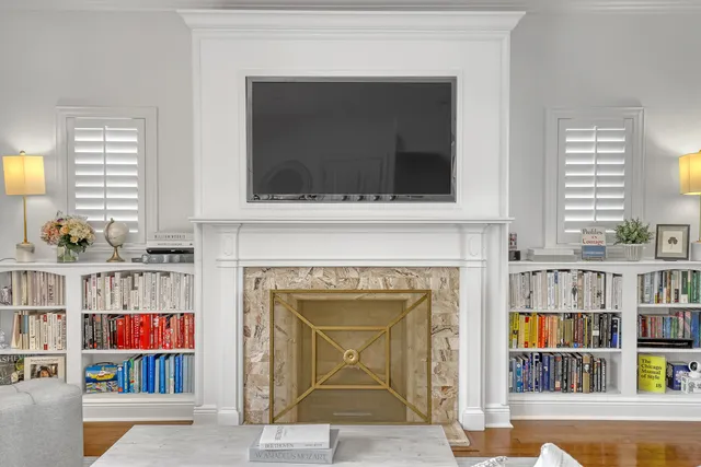 a living room with bookshelf and a fireplace